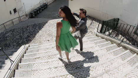 Young-couple-walking-down-stairs-in-street.